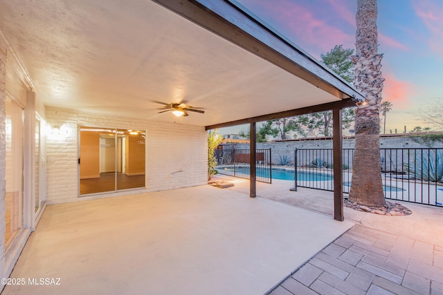 view of patio / terrace with fence, a ceiling fan, and a fenced in pool