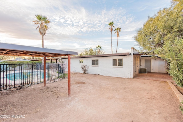 exterior space featuring central AC unit, a patio area, fence, and brick siding