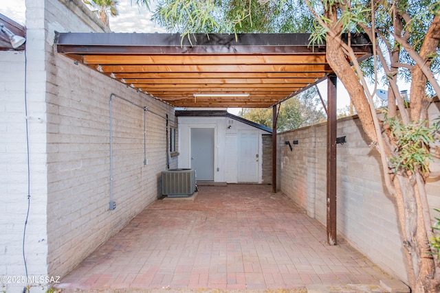 view of patio featuring an outbuilding, a shed, fence, and central air condition unit