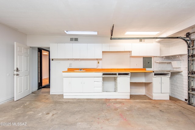 garage featuring electric panel, visible vents, and a sink