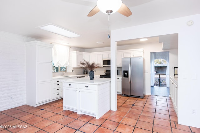 kitchen with white cabinetry, appliances with stainless steel finishes, light countertops, and a sink