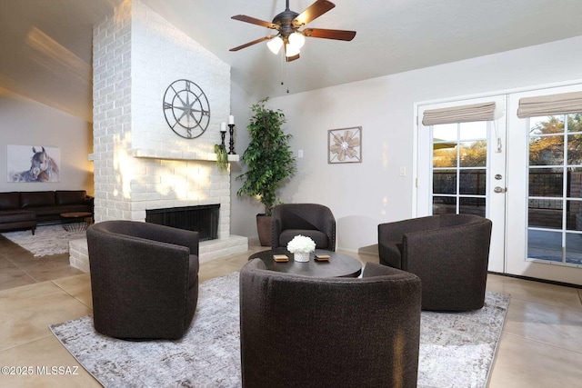 tiled living room with a ceiling fan, lofted ceiling, french doors, and a fireplace