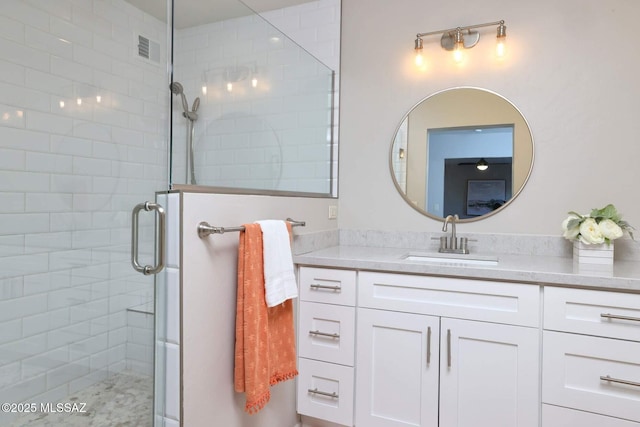 bathroom featuring visible vents, a shower stall, and vanity