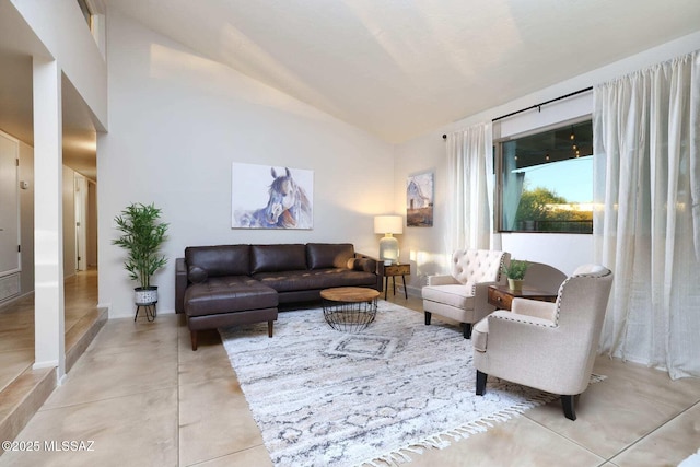 living room featuring high vaulted ceiling and light tile patterned floors