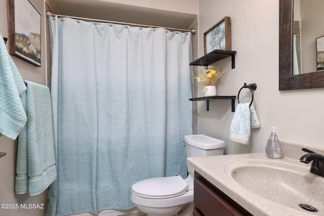 bathroom featuring curtained shower, vanity, and toilet