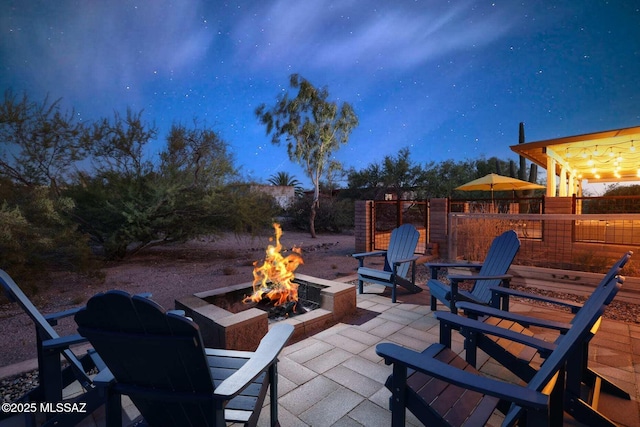 view of patio with fence and a fire pit