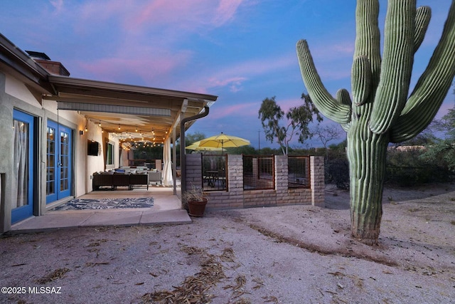 exterior space featuring french doors, outdoor lounge area, and fence