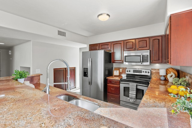 kitchen with light stone countertops, visible vents, a sink, and appliances with stainless steel finishes