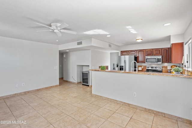 kitchen with light tile patterned floors, a peninsula, visible vents, appliances with stainless steel finishes, and wine cooler