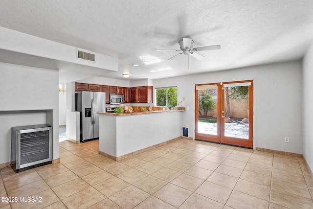 kitchen featuring light tile patterned floors, visible vents, appliances with stainless steel finishes, and a peninsula