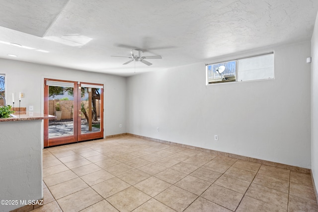 empty room featuring light tile patterned floors, french doors, baseboards, and ceiling fan