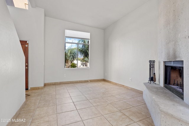 unfurnished living room featuring light tile patterned floors and a fireplace