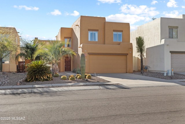 pueblo-style home with concrete driveway, an attached garage, fence, and stucco siding