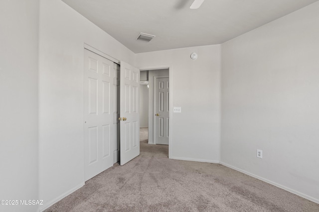 unfurnished bedroom featuring a ceiling fan, carpet, visible vents, baseboards, and a closet