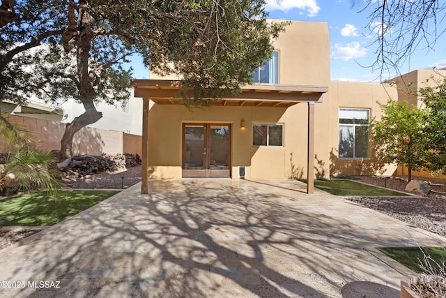 back of property with a patio area, french doors, fence, and stucco siding