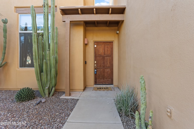 entrance to property featuring stucco siding