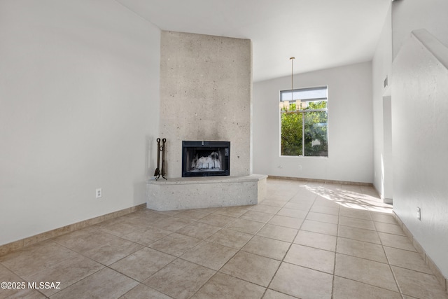 unfurnished living room featuring a premium fireplace, baseboards, and light tile patterned flooring