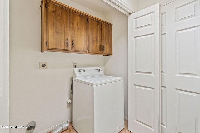 clothes washing area featuring cabinet space and washer / dryer