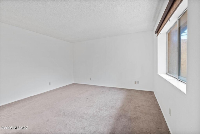 carpeted empty room featuring a textured ceiling