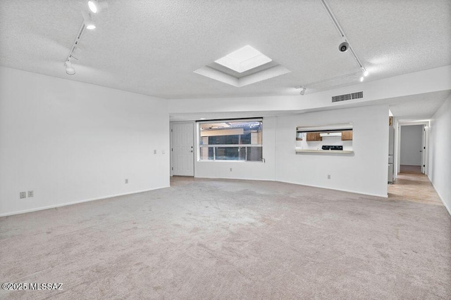 unfurnished living room with carpet floors, visible vents, and a textured ceiling