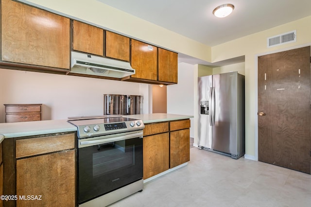 kitchen featuring under cabinet range hood, stainless steel appliances, visible vents, light countertops, and brown cabinets