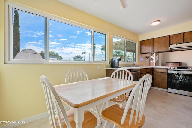 dining space featuring ceiling fan and baseboards