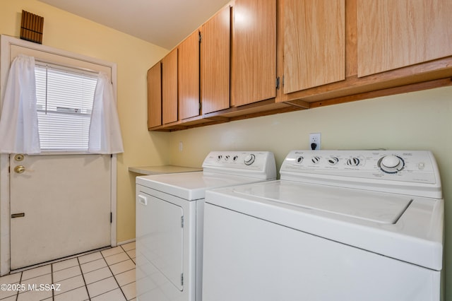 laundry area featuring cabinet space, washer and dryer, and light tile patterned flooring