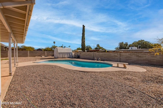 view of pool featuring a patio area, a fenced backyard, an outbuilding, and a shed