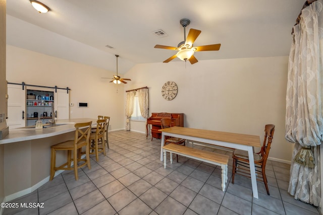 10117 E Sky Castle Way, Tucson, AZ 85730 - dining area with tile patterned floors, a ceiling fan, a barn door, lofted ceiling, and visible vents
