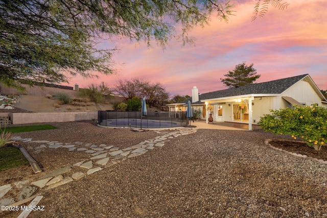 10117 E Sky Castle Way, Tucson, AZ 85730 - yard at dusk featuring a fenced in pool, fence, and a patio