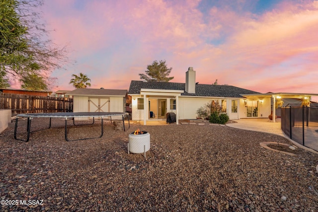 10117 E Sky Castle Way, Tucson, AZ 85730 - rear view of house featuring an outdoor structure, a fenced backyard, a storage shed, a patio area, and a chimney