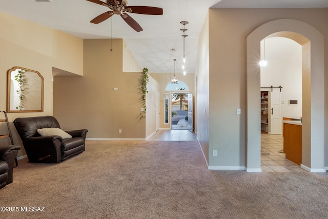 10117 E Sky Castle Way, Tucson, AZ 85730 - living area with light tile patterned flooring, high vaulted ceiling, a ceiling fan, light carpet, and arched walkways