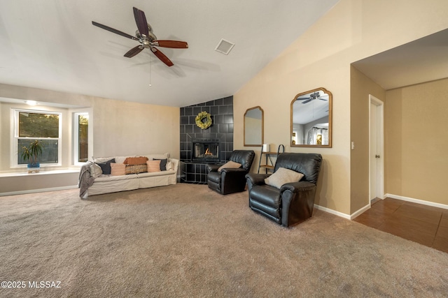10117 E Sky Castle Way, Tucson, AZ 85730 - carpeted living room with a tile fireplace, lofted ceiling, baseboards, visible vents, and ceiling fan