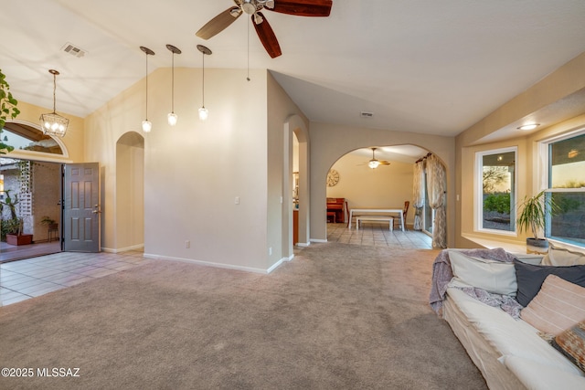 10117 E Sky Castle Way, Tucson, AZ 85730 - tiled living area with vaulted ceiling, carpet flooring, a ceiling fan, visible vents, and arched walkways