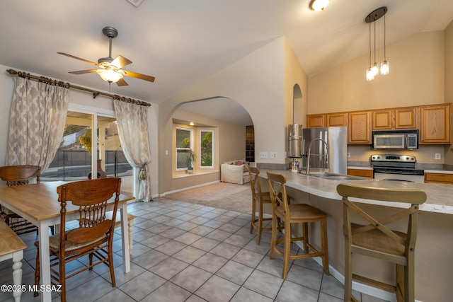 10117 E Sky Castle Way, Tucson, AZ 85730 - kitchen with a kitchen breakfast bar, stainless steel appliances, arched walkways, and ceiling fan