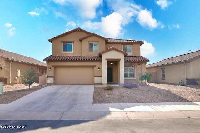 mediterranean / spanish house featuring a tile roof, stucco siding, an attached garage, and concrete driveway