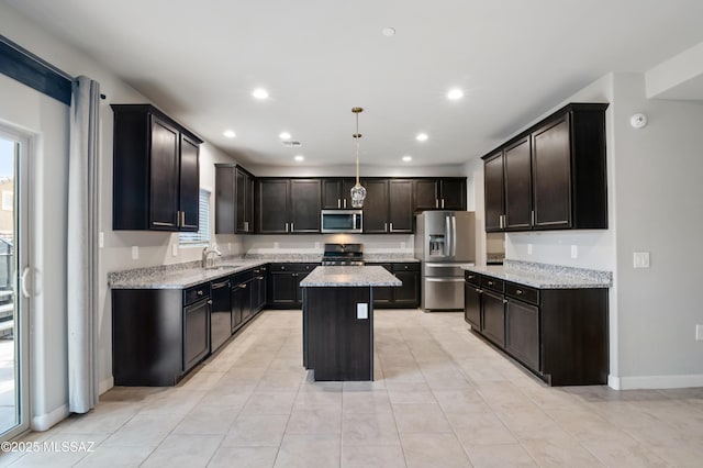 kitchen with light stone counters, baseboards, recessed lighting, stainless steel appliances, and a center island