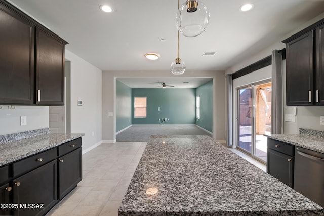 kitchen with visible vents, decorative light fixtures, open floor plan, stone counters, and stainless steel dishwasher