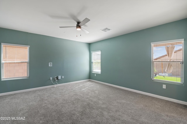 spare room with ceiling fan, carpet, visible vents, and baseboards