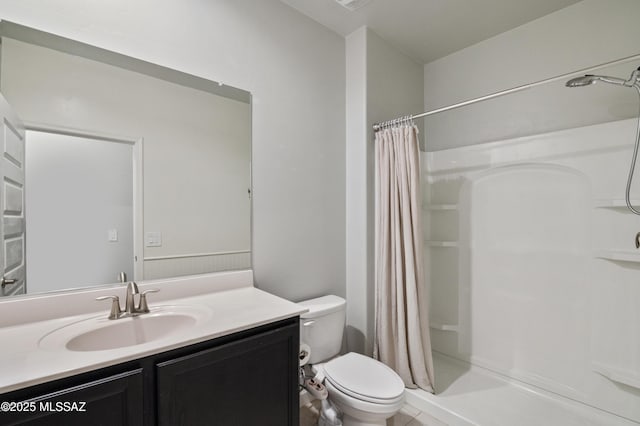 bathroom featuring toilet, a stall shower, and vanity