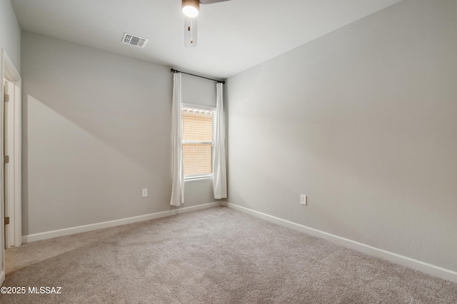 unfurnished room featuring carpet flooring, visible vents, and baseboards