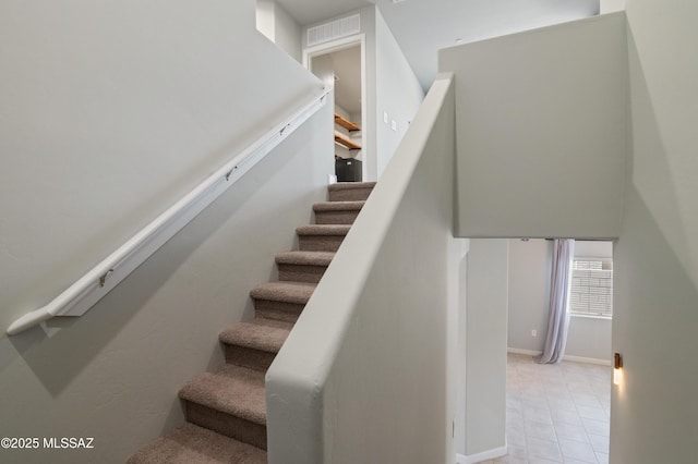 staircase with tile patterned floors and visible vents