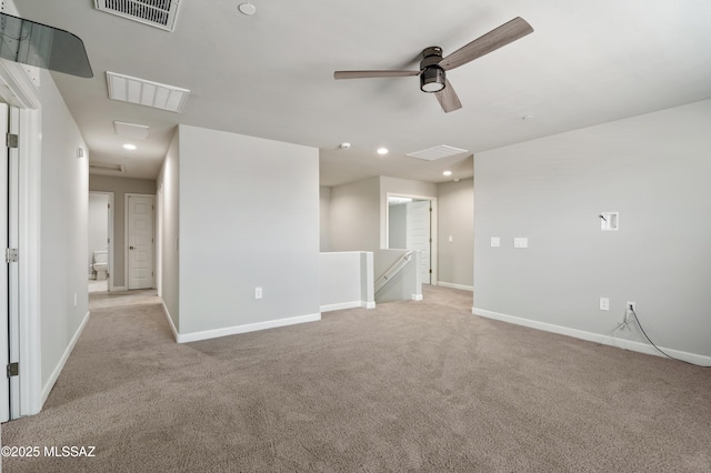 spare room featuring light carpet, visible vents, attic access, and baseboards