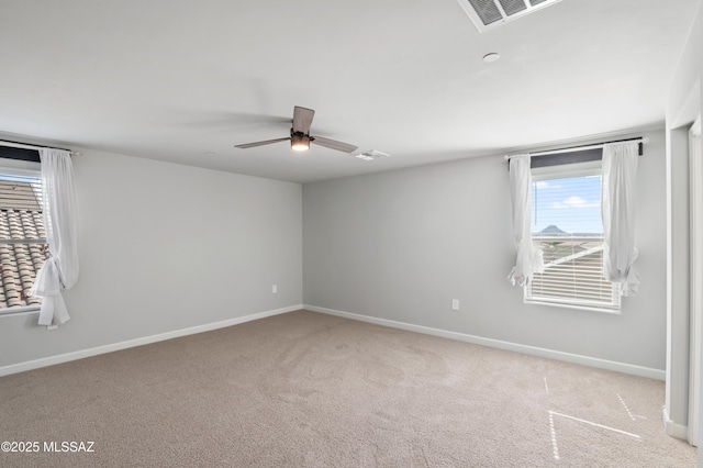 empty room with visible vents, ceiling fan, baseboards, and carpet floors