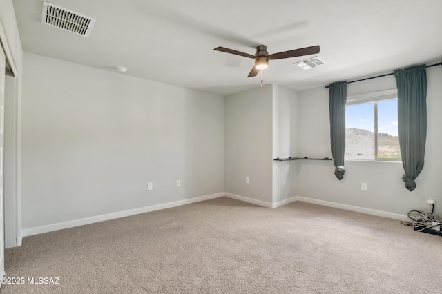 spare room featuring visible vents, carpet flooring, baseboards, and ceiling fan