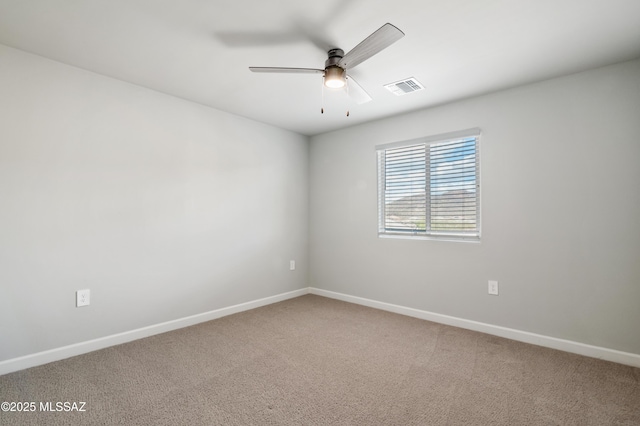 carpeted empty room with visible vents, a ceiling fan, and baseboards