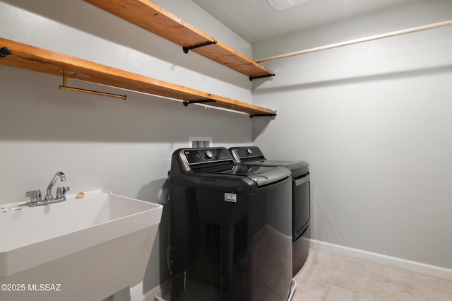 laundry area featuring a sink, baseboards, laundry area, and washer and clothes dryer