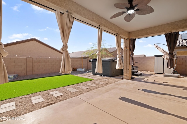 view of patio / terrace featuring ceiling fan, a fenced backyard, and a hot tub