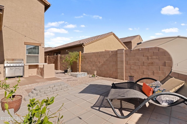 view of patio featuring an outdoor kitchen, fence, and grilling area