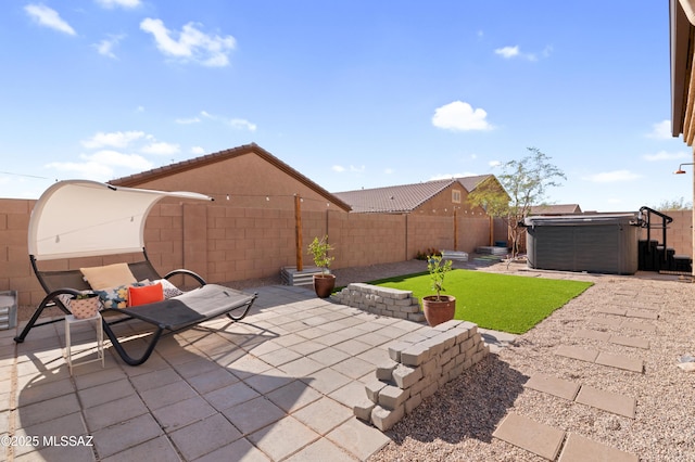 view of patio / terrace with a hot tub and a fenced backyard